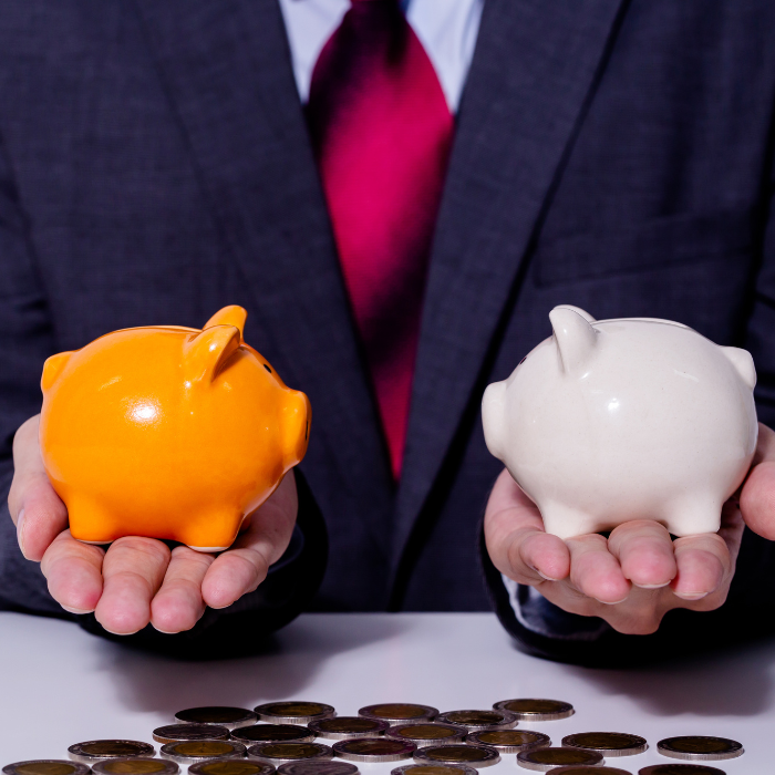 man holds two piggy banks, one in each hand